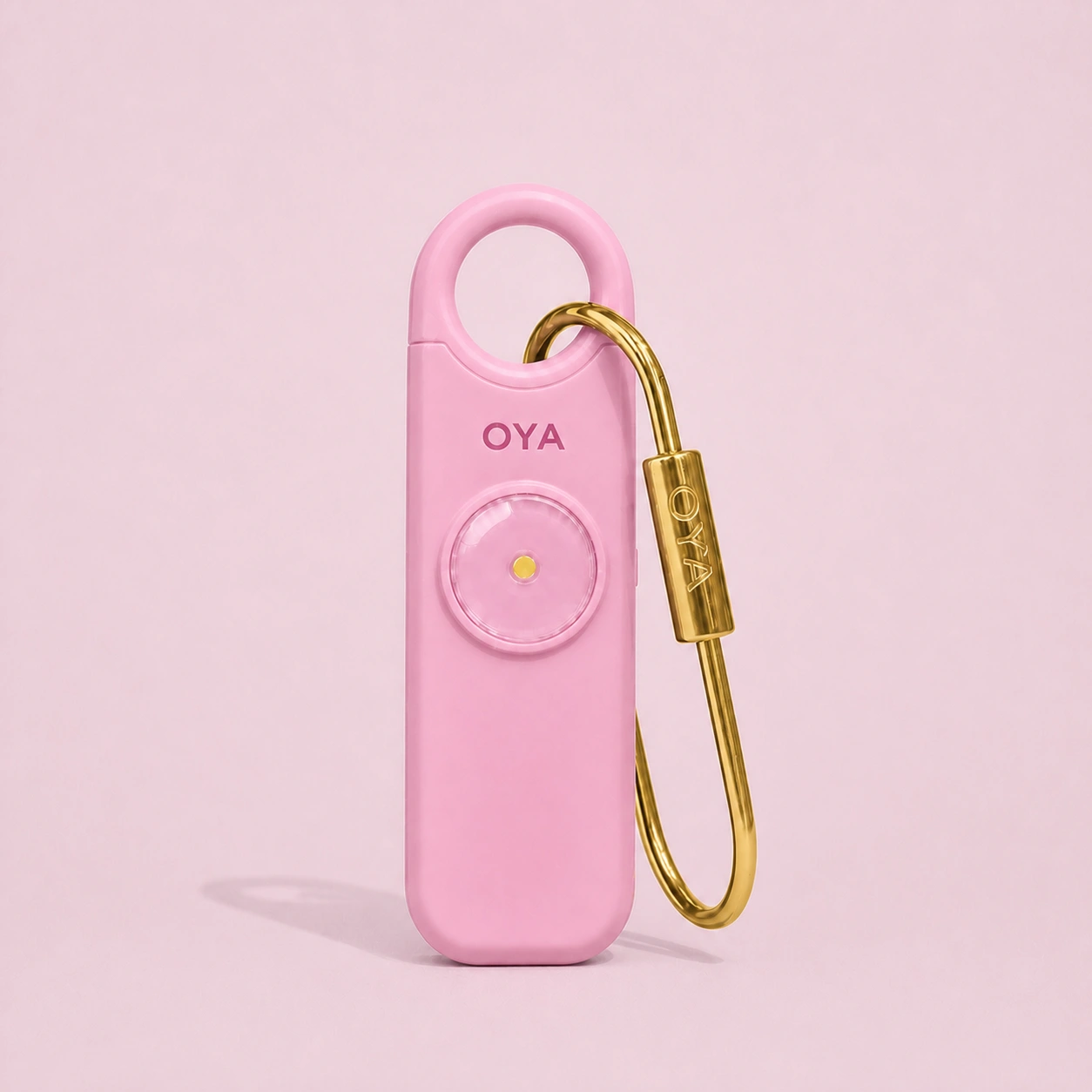 L’alarme personnelle OYA en Persian Pink avec son clip doré, sur un fond assorti à la teinte